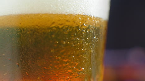 Macro-shot-of-a-beer-glass-with-cold-beer-bubbles-rise-in-the-glass.-Slow-motion-beer-bubbles